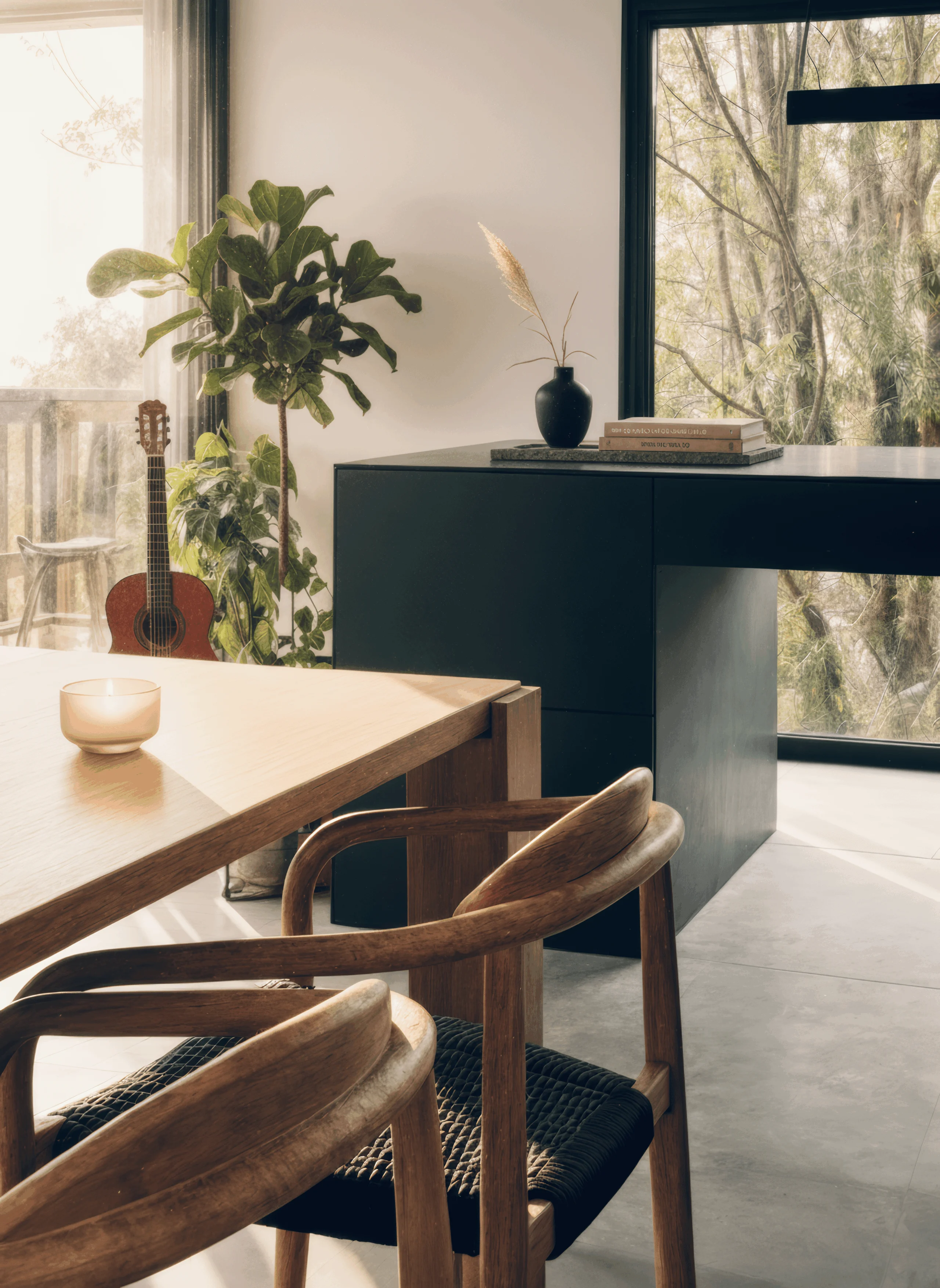 Mesa y sillas de madera junto a la isla de cocina y los ventanales.