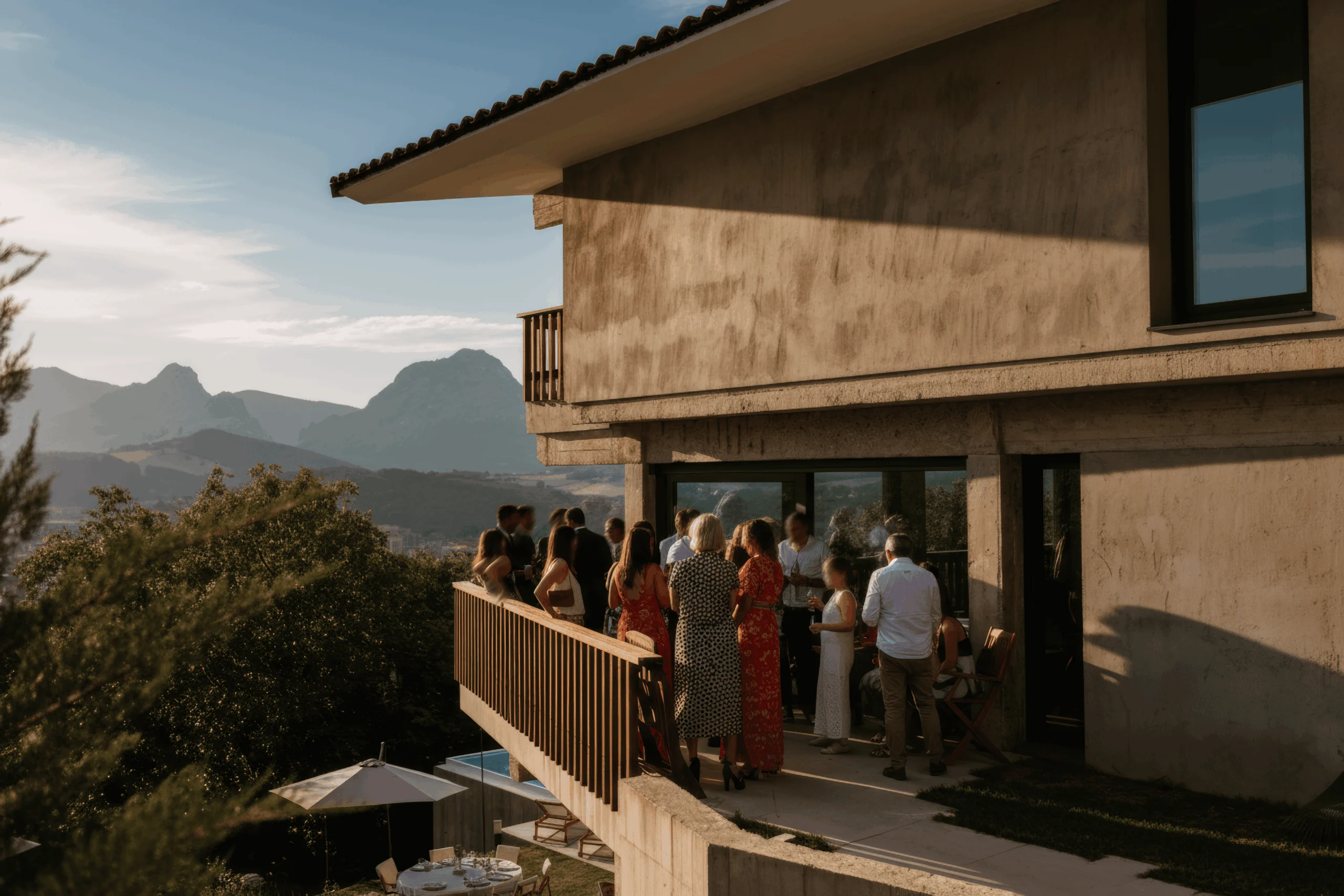 Personas en la terraza de Mañariku, con barandilla de madera y vistas a las montañas.